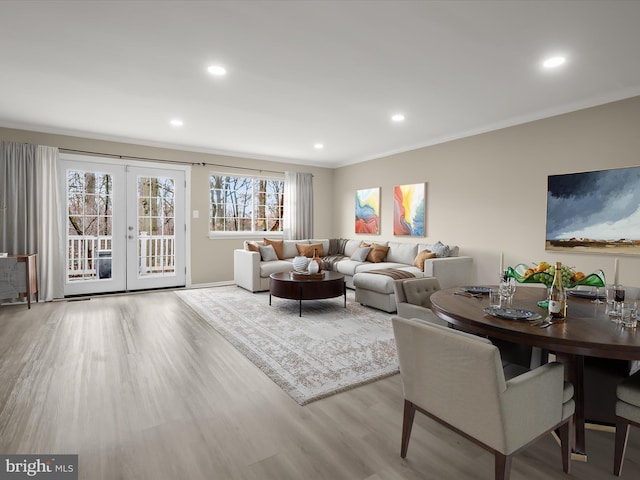 living room with crown molding, french doors, and light wood-type flooring