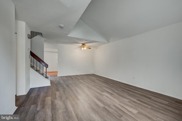 unfurnished living room featuring a textured ceiling, hardwood / wood-style flooring, high vaulted ceiling, and ceiling fan