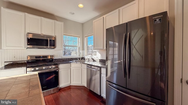 kitchen featuring white cabinets, appliances with stainless steel finishes, sink, and dark hardwood / wood-style floors