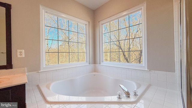 bathroom featuring tiled bath and vanity