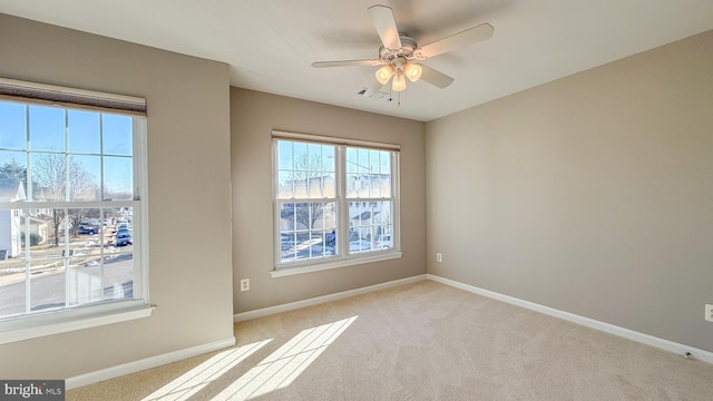 spare room featuring ceiling fan and light colored carpet