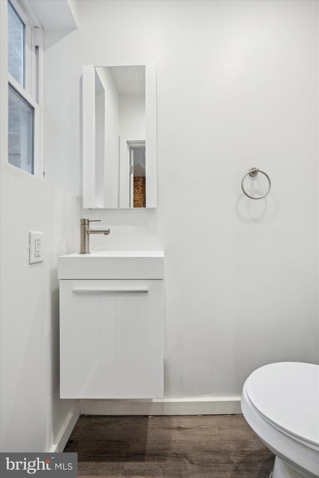 bathroom with hardwood / wood-style floors, vanity, and toilet