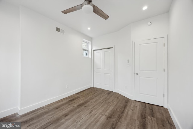 unfurnished bedroom with ceiling fan, a closet, and dark wood-type flooring