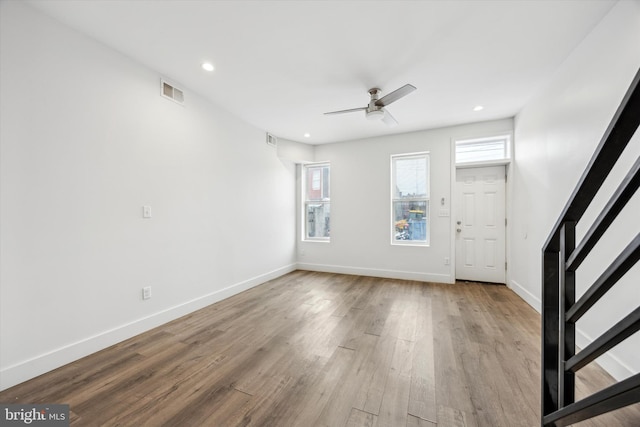 foyer entrance with ceiling fan and light wood-type flooring