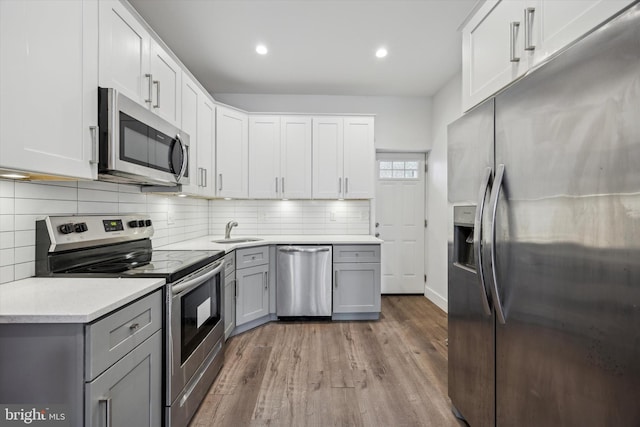 kitchen featuring appliances with stainless steel finishes, white cabinetry, gray cabinetry, and hardwood / wood-style floors