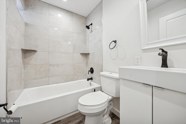 full bathroom with hardwood / wood-style floors, vanity, tiled shower / bath combo, and toilet