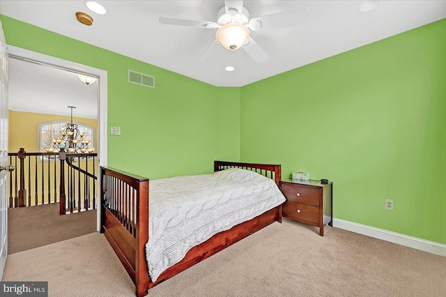 bedroom with light colored carpet and ceiling fan with notable chandelier