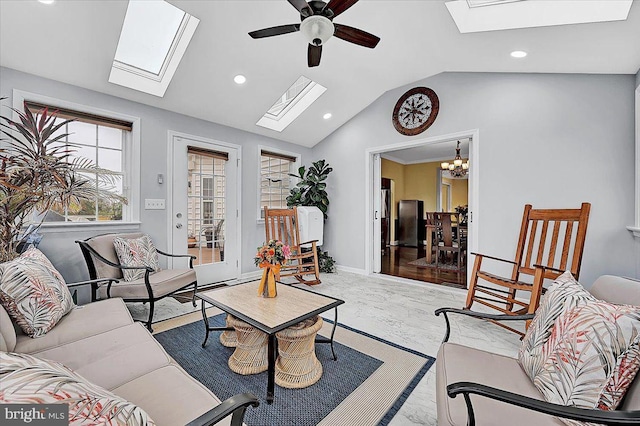 living room with lofted ceiling with skylight and ceiling fan with notable chandelier