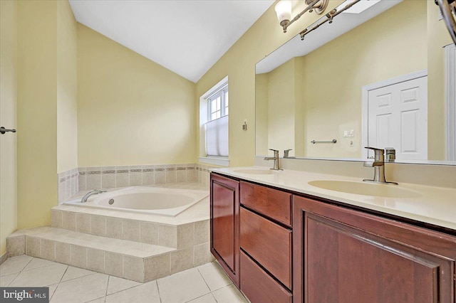 bathroom with tile patterned flooring, vanity, a relaxing tiled tub, and vaulted ceiling