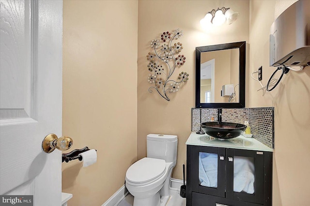 bathroom featuring vanity, toilet, and tasteful backsplash