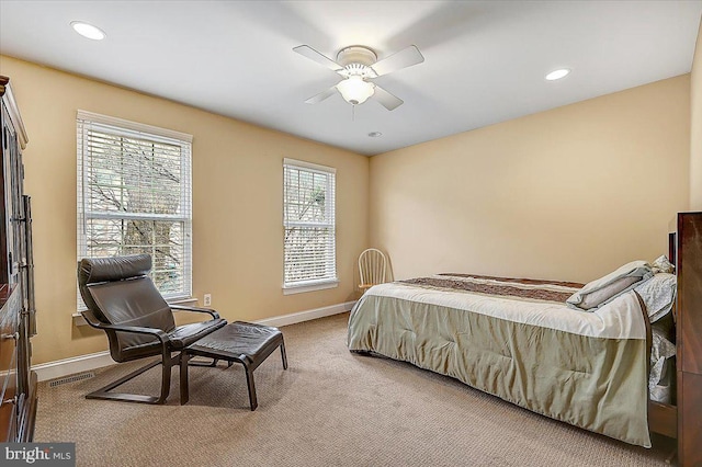 bedroom with multiple windows, light carpet, and ceiling fan