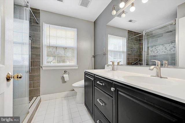 bathroom with tile patterned flooring, vanity, tiled shower, and toilet