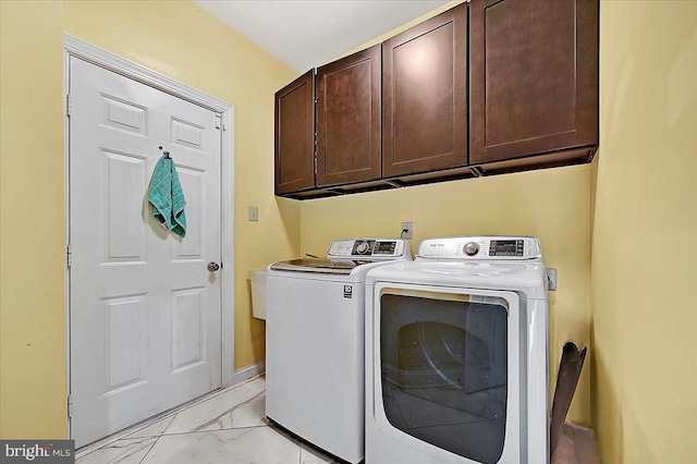 washroom featuring separate washer and dryer and cabinets