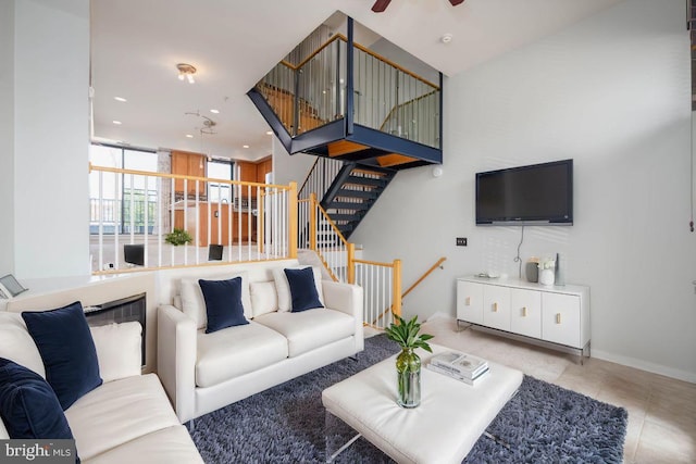 tiled living room with baseboards, stairway, a ceiling fan, and recessed lighting