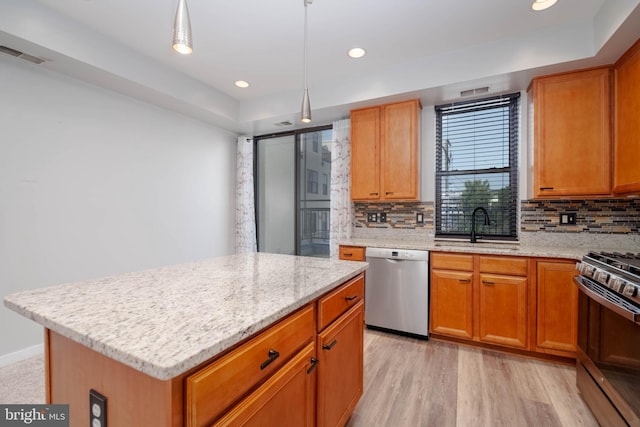 kitchen with visible vents, backsplash, stainless steel dishwasher, a sink, and gas stove