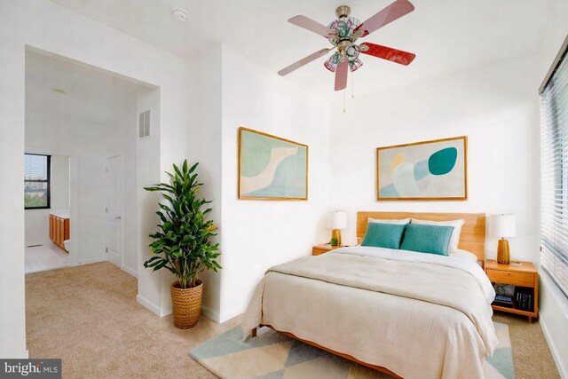 carpeted bedroom with visible vents, baseboards, and multiple windows