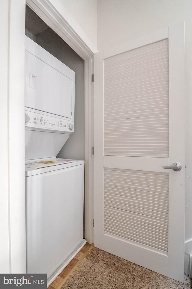 clothes washing area with laundry area and stacked washer / dryer