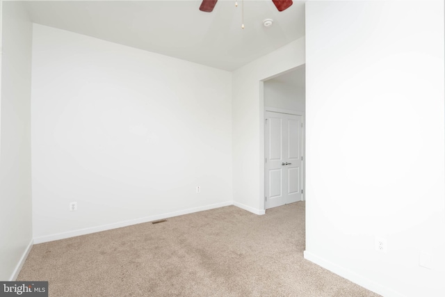 spare room with baseboards, visible vents, ceiling fan, and carpet flooring