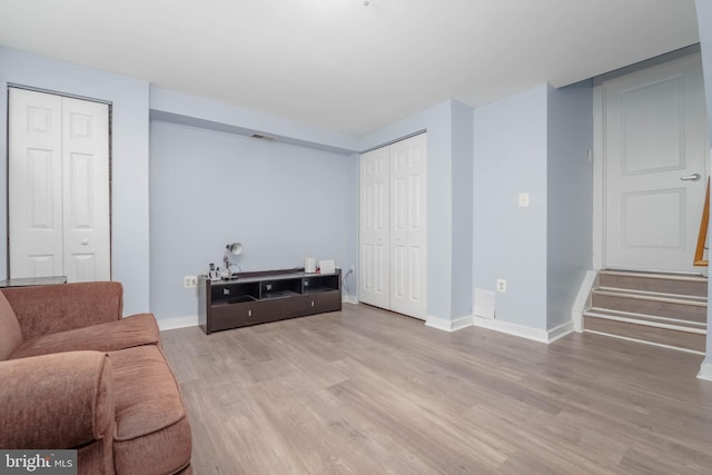 living room featuring stairway, wood finished floors, and baseboards