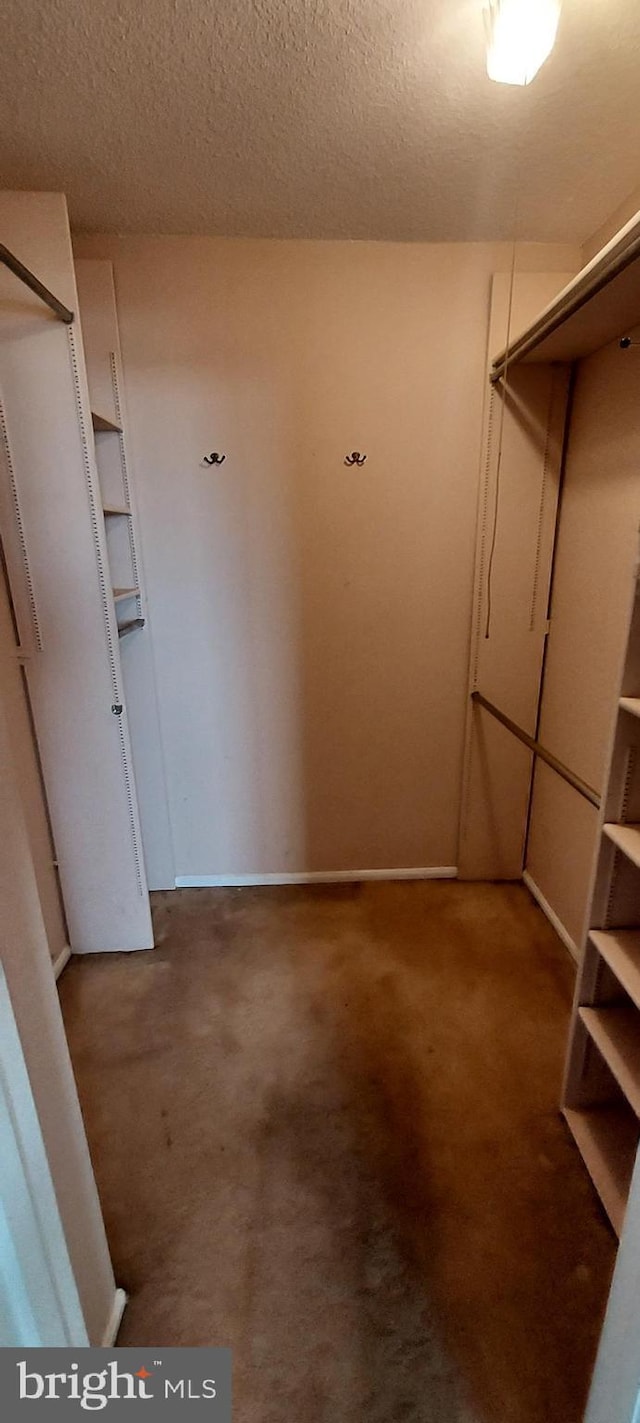 spacious closet featuring dark carpet