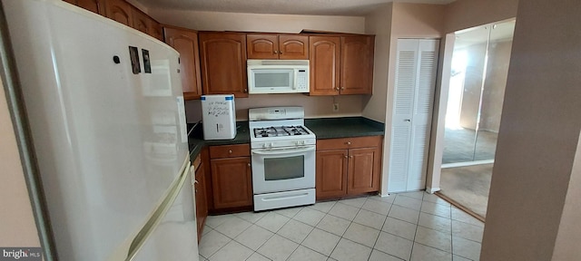 kitchen featuring light tile patterned floors and white appliances