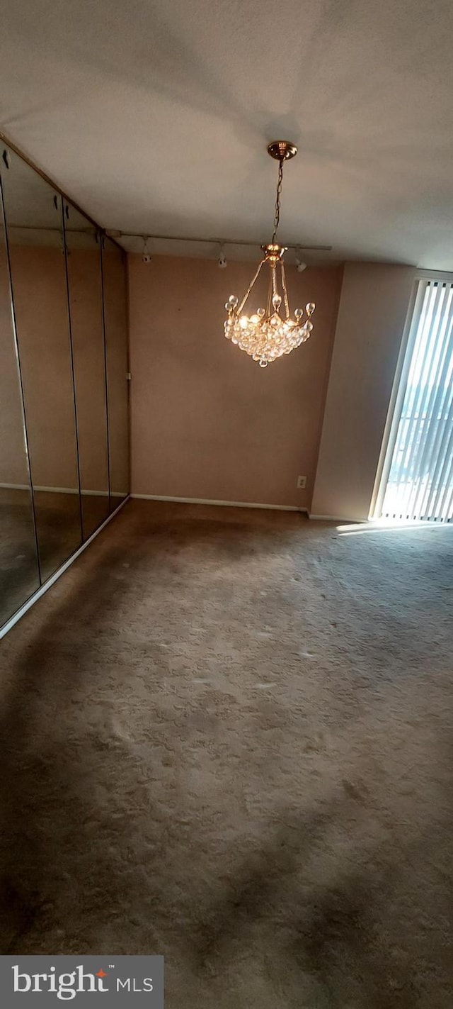 unfurnished dining area featuring a chandelier