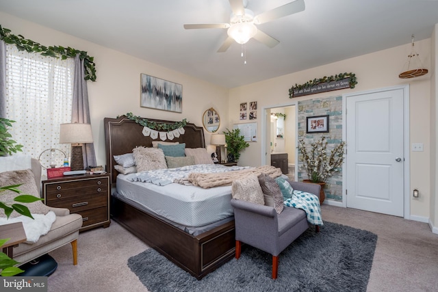 bedroom with ceiling fan, light colored carpet, and ensuite bathroom