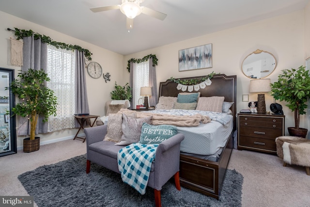 bedroom featuring multiple windows, ceiling fan, and light carpet