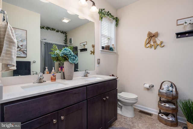 bathroom featuring tile patterned flooring, a shower with curtain, vanity, and toilet