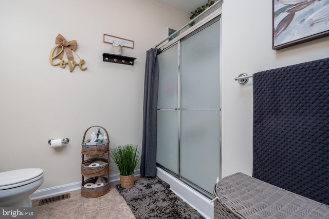 bathroom with tile patterned floors, an enclosed shower, and toilet