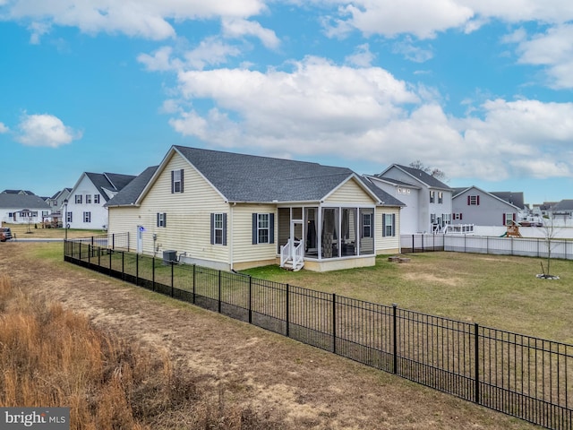 rear view of property featuring a sunroom, a yard, and central air condition unit