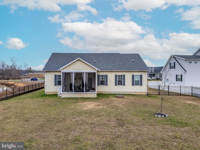 rear view of property featuring a sunroom and a lawn