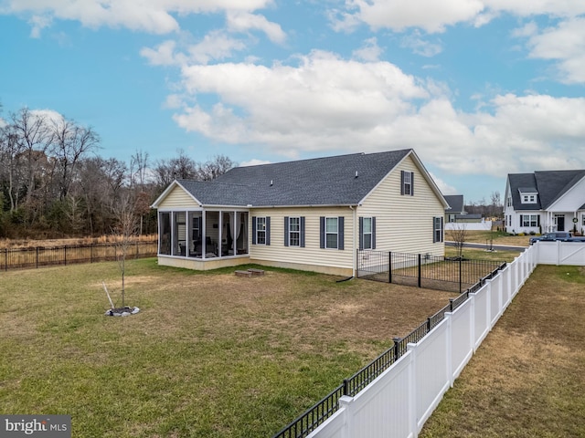 rear view of property with a lawn and a sunroom