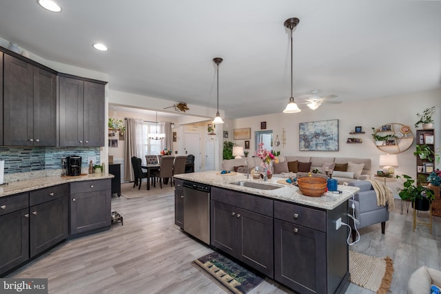 kitchen with dark brown cabinetry, sink, pendant lighting, dishwasher, and light hardwood / wood-style floors