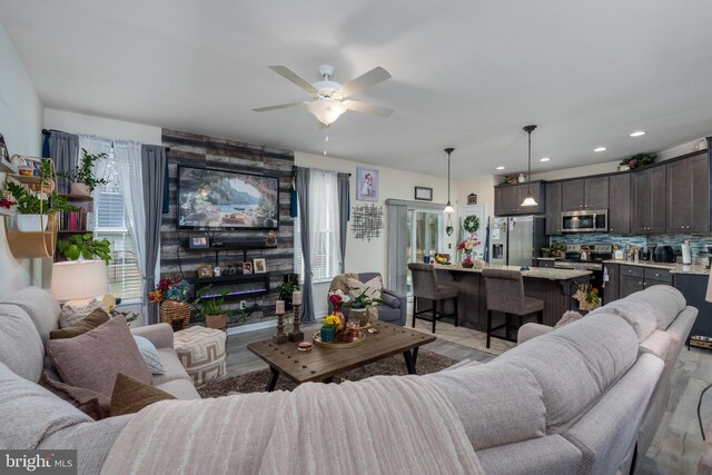 living room featuring ceiling fan and light hardwood / wood-style flooring