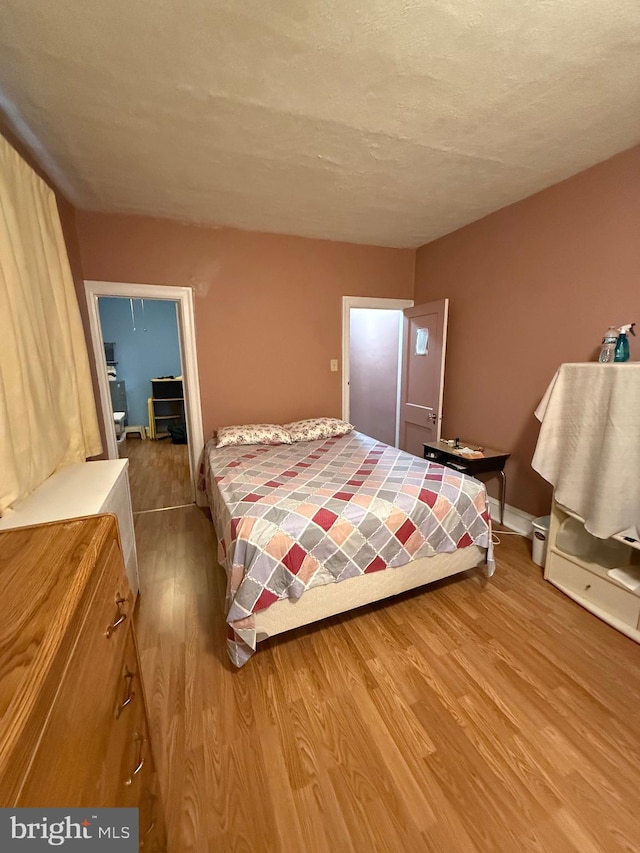 bedroom with hardwood / wood-style floors and a textured ceiling