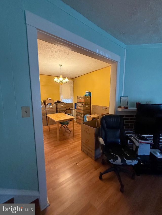 office featuring wood-type flooring, a textured ceiling, and a notable chandelier