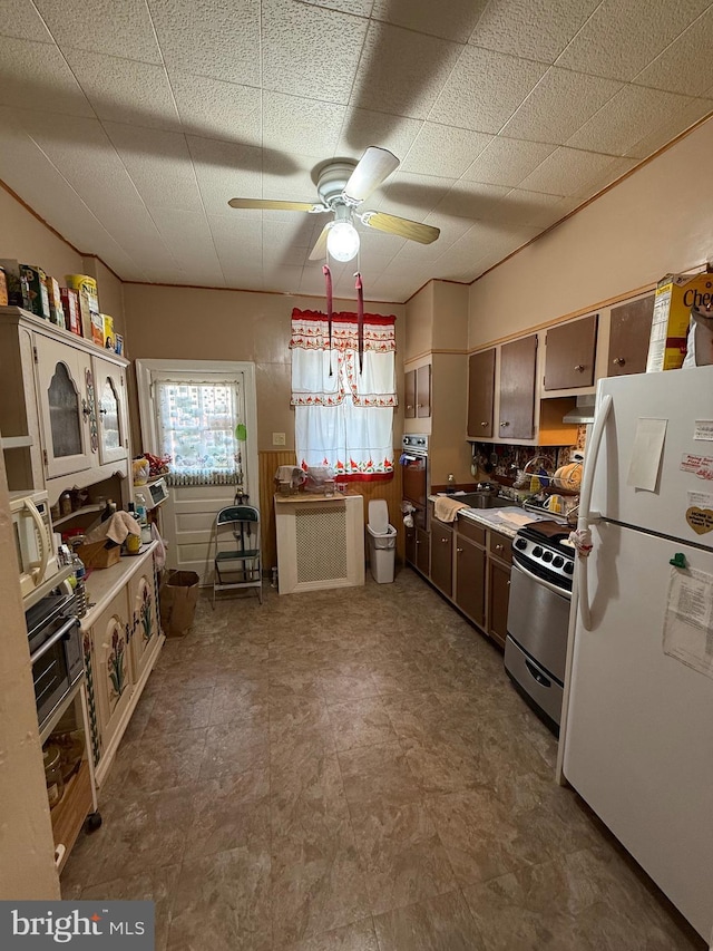 kitchen with decorative backsplash, stainless steel appliances, ceiling fan, and range hood