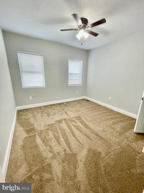 carpeted spare room with ceiling fan and a healthy amount of sunlight