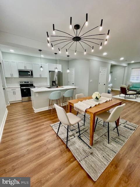 dining room featuring light hardwood / wood-style flooring and a notable chandelier