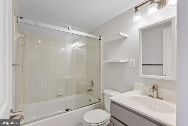 full bathroom with combined bath / shower with glass door, vanity, and toilet