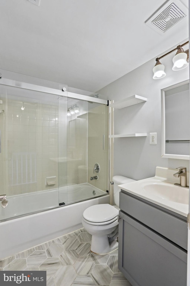 full bathroom featuring vanity, toilet, and bath / shower combo with glass door