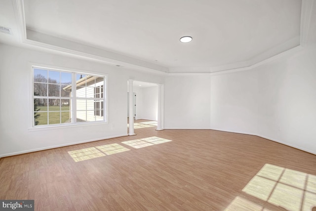 unfurnished room with a raised ceiling and hardwood / wood-style flooring