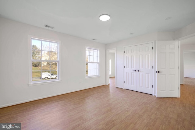 unfurnished bedroom featuring a closet and light hardwood / wood-style flooring