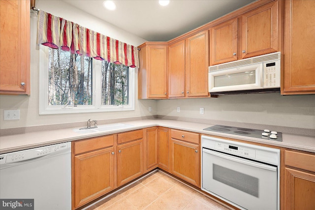 kitchen with light tile patterned floors, white appliances, and sink