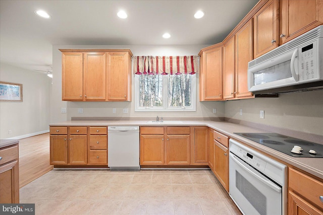 kitchen featuring ceiling fan, sink, and white appliances