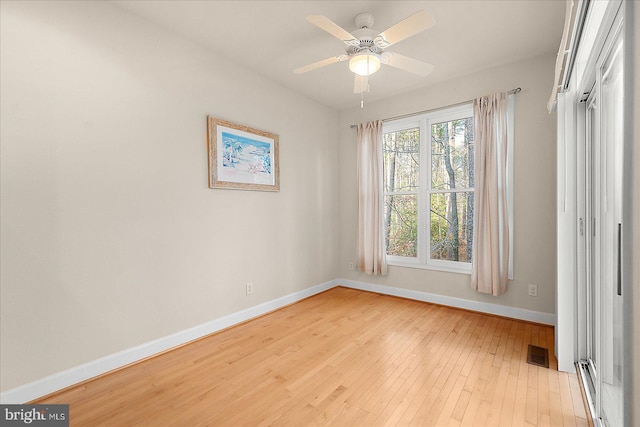 empty room with ceiling fan and light hardwood / wood-style flooring