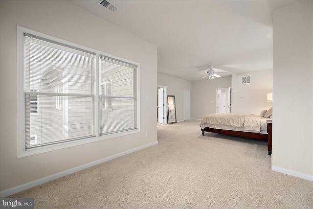 bedroom featuring ceiling fan, light colored carpet, and multiple windows