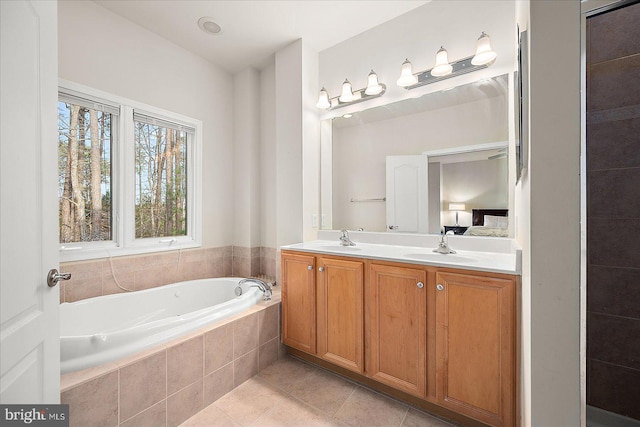 bathroom featuring tile patterned flooring, vanity, and tiled tub