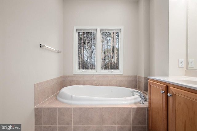 bathroom featuring vanity and a relaxing tiled tub